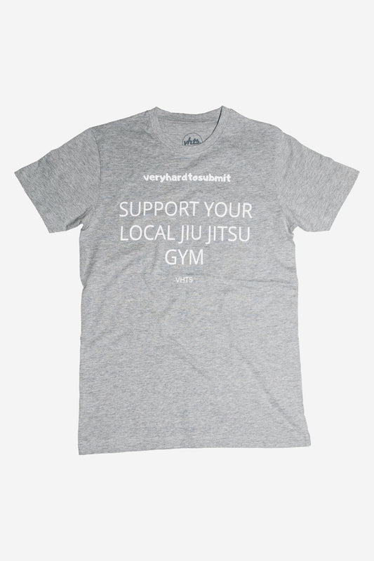 S.Y.L.J.J.G. TEE Heather Grey Support your local Jiu Jitsu Gym 90 % Cotton 10% viscose Slim fit screen print letters on the front Weight 180GSM To avoid shrinking, wash at 30 Degrees and do not tumble dry. Hang dry post wash and iron out flat avoiding the design. vhts europe